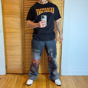 Blue denim jeans with 9_11 Twin Towers explosion graphic featuring fiery orange blasts and black smoke on the legs model picture